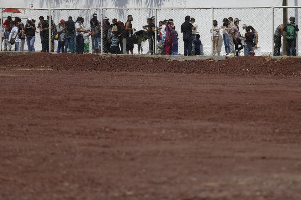 Residents wait in line for a chance to try out a new aerial gondola public transit system dubbed the Cablebus, outside the Campos Revolucion station in the Cuautepec neighborhood of northern Mexico City, Thursday, March 4, 2021. For the residents of Cuautepec, this new system, the first of four planned lines, will turn a commute to the nearest subway station, that can last up to two hours, into a 30-minute ride. (AP Photo/Rebecca Blackwell)