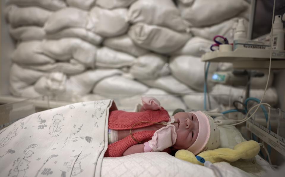 An infant rests in a cot in front of a window protected by sandbags in an intensive care for newborns at Okhmatdyt Hospital in Kyiv - Jeff J Mitchell/Getty Images