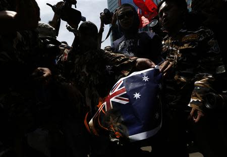 Protesters burn an Australian flag during a protest in front of the Australia embassy in Jakarta, November 21, 2013. Australia warned travellers to Indonesia of a planned demonstration at its embassy in Jakarta on Thursday as anger grows over reports Canberra spied on top Indonesians, including the president and his wife. REUTERS/Beawiharta