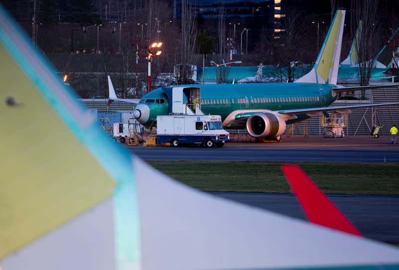 A service truck is seen stopped next to a Boeing 737 Max aircraft in storage at the Renton Municipal Airport in Renton