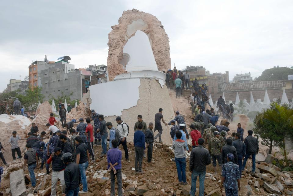 Nepalese rescue members and onlookers gather at the collapsed Dharahara Tower in Kathmandu on April 25, 2015. (PRAKASH MATHEMA/AFP/Getty Images)