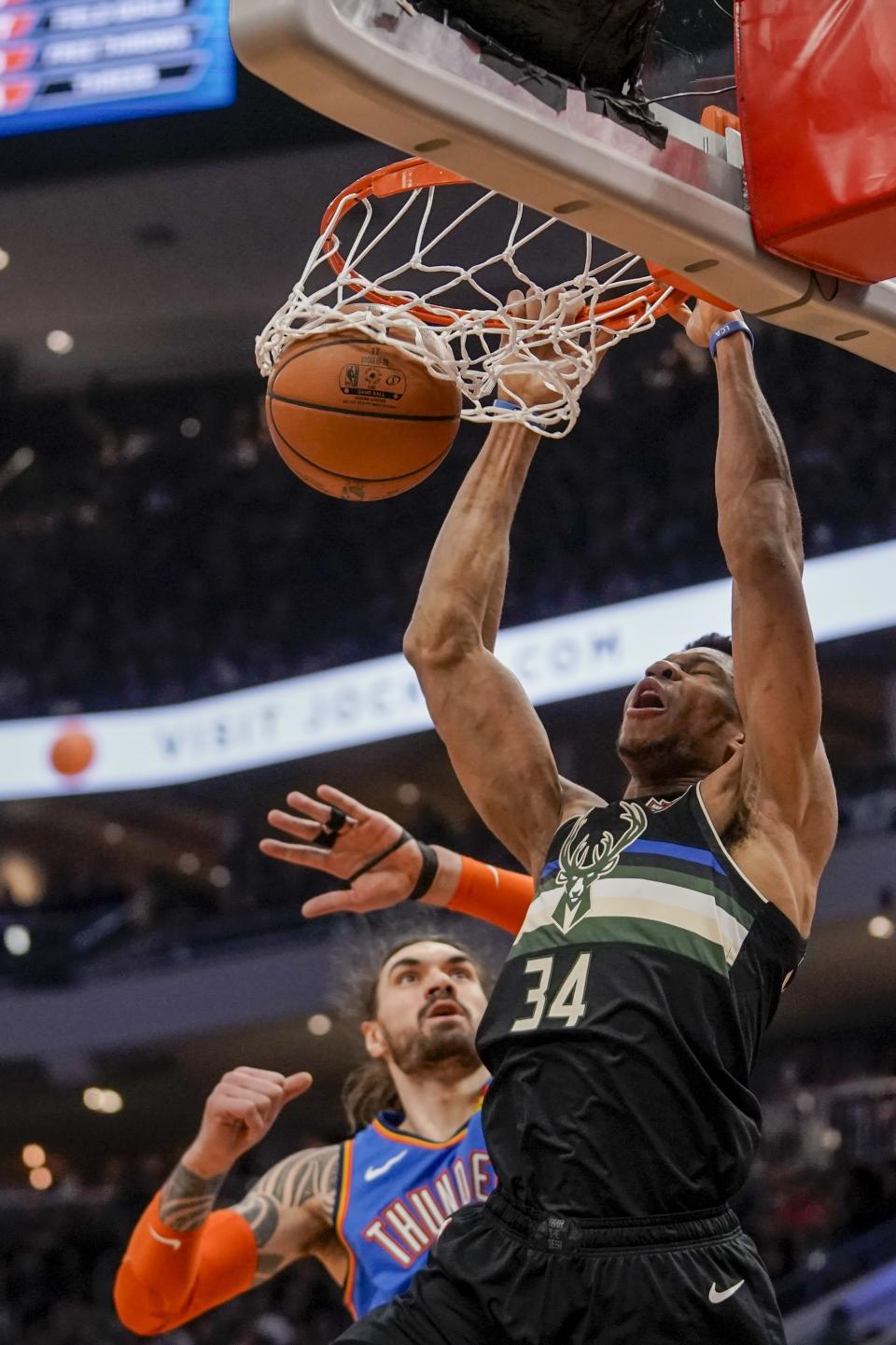 Milwaukee Bucks' Giannis Antetokounmpo dunks over Oklahoma City Thunder's Steven Adams during the second half of an NBA basketball game Friday, Feb. 28, 2020, in Milwaukee. (AP Photo/Morry Gash)