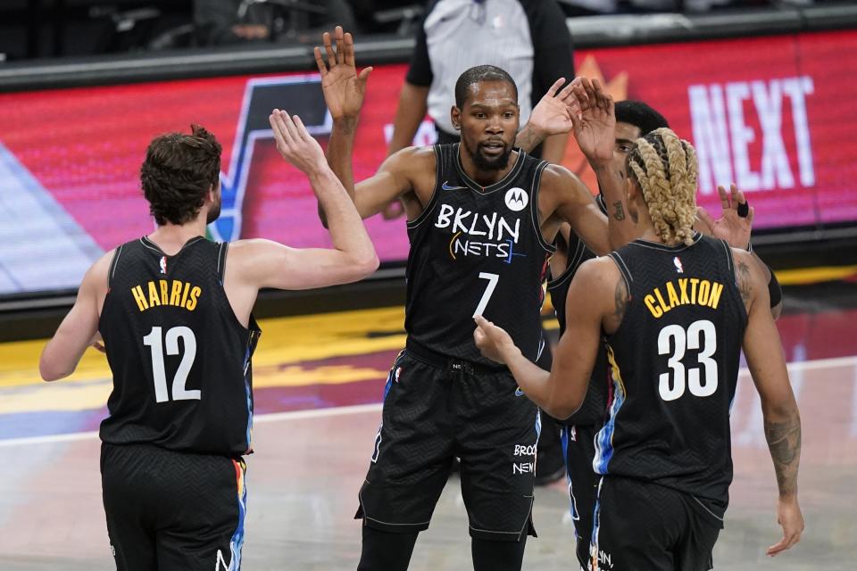 Brooklyn Nets' Kevin Durant (7) high-fives teammates Joe Harris (12) and Nicolas Claxton (33) during the first half of an NBA basketball game against the New Orleans Pelicans Wednesday, April 7, 2021, in New York. (AP Photo/Frank Franklin II)