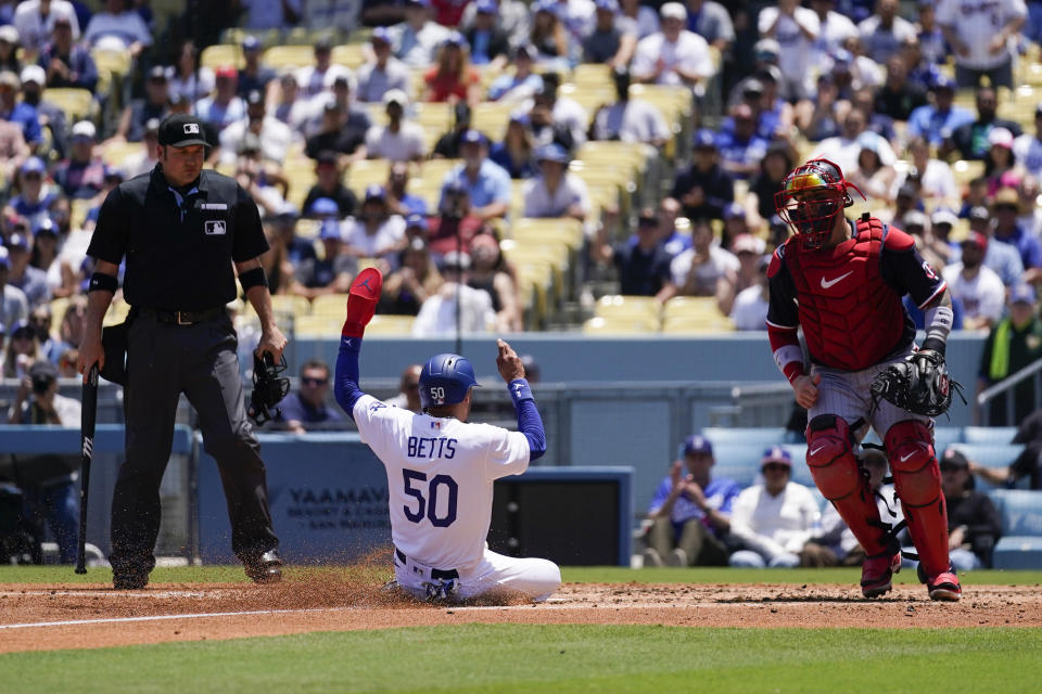 Los Angeles Dodgers' Mookie Betts (50) scores off of a sacrifice fly hit by Freddie Freeman during the third inning of a baseball game against the Minnesota Twins in Los Angeles, Wednesday, May 17, 2023. (AP Photo/Ashley Landis)