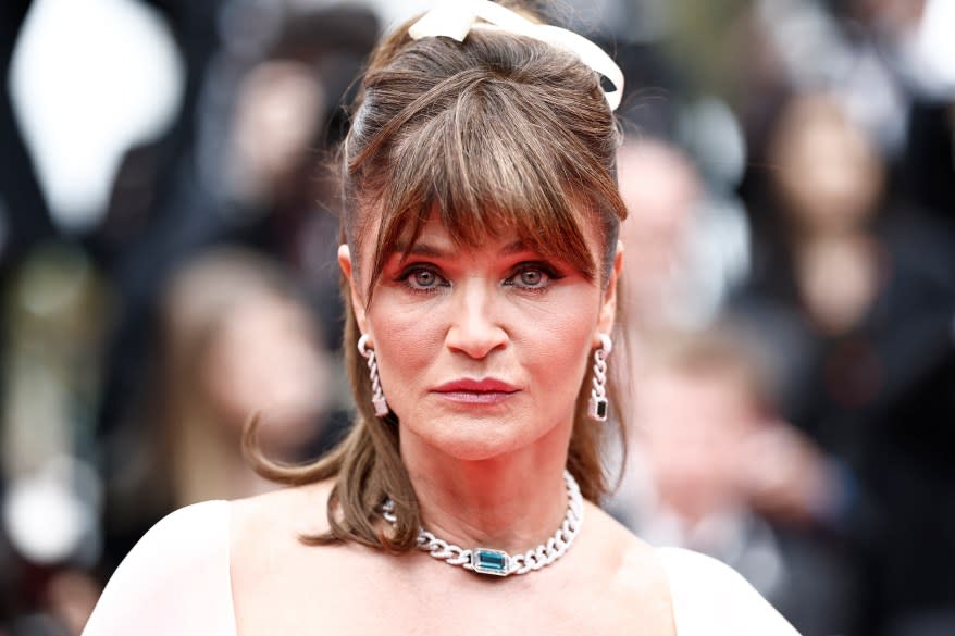 Helena Christensen arriving at the 77th Cannes Film Festival in a white dress