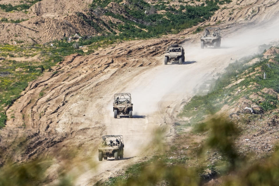 Israeli soldiers drive in the Gaza Strip, as seen from southern Israel, Sunday, Feb. 4, 2024. The army is battling Palestinian militants across Gaza in the war ignited by Hamas' Oct. 7 attack into Israel. (AP Photo/Ariel Schalit)