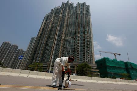 A worker from Food and Environmental Hygiene Department disinfects a drain near a residential area in Hong Kong, China August 26, 2016, after the first case of Zika was confirmed in the city. REUTERS/Bobby Yip