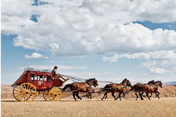 The Wells Fargo state coach traveling over grasslands.