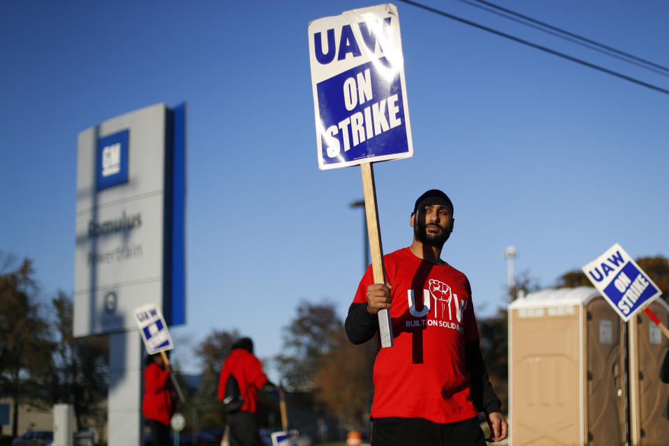 A member of the United Auto Workers walks the picket line at the General Motors Romulus Powertrain plant in Romulus, Mich., Wednesday, Oct. 9, 2019. Nearly four weeks into the United Auto Workers' strike against GM, employees are starting to feel the pinch of going without their regular paychecks. (AP Photo/Paul Sancya)