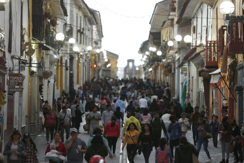 People walk on a street in Ayacucho, Peru, Sunday, Dec. 18, 2022. Peru’s caretaker president, Dina Boluarte, has tried to quell protests, emphasizing her own humble roots and support for protesters' demands that elections, scheduled for 2026, be pushed up to next year. (AP Photo/Hugo Curotto)