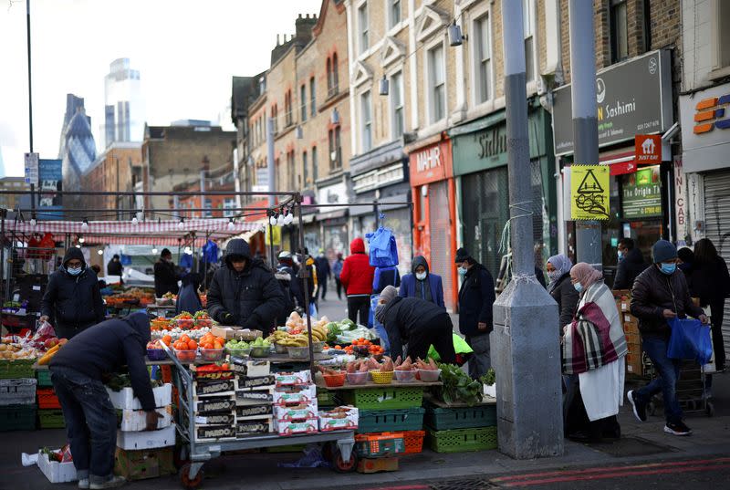 FILE PHOTO: People shop at a market stalls in east London