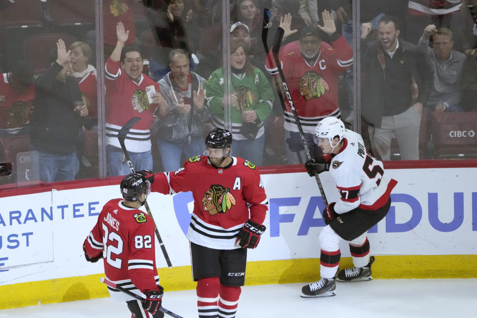 Chicago Blackhawks' Seth Jones, center, celebrates with Caleb Jones (82) after scoring as Ottawa Senators' Shane Pinto skates behind them during the second period of an NHL hockey game Monday, March 6, 2023, in Chicago. (AP Photo/Charles Rex Arbogast)