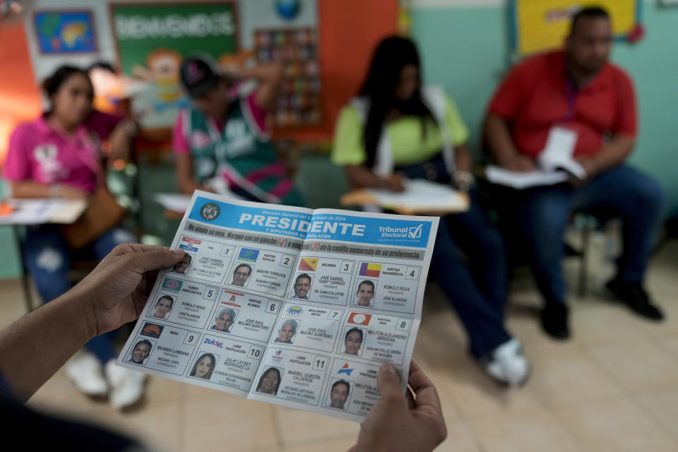 An electoral worker holds a ballot as he counts them after general elections polls closed in Panama City, Sunday, May 5, 2024. (AP Photo/Matias Delacroix)