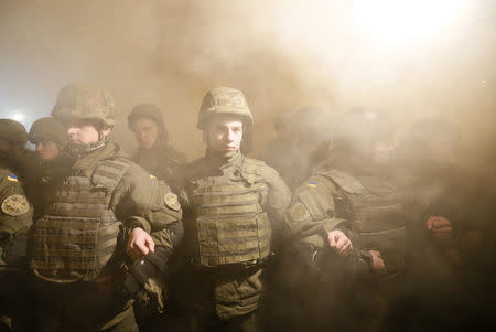 Law enforcement officers stand guard as activists of nationalist groups gather to support participants of the blockade, which recently stopped rail shipments from separatist-controlled areas, and to mark the Ukrainian Military Volunteer Day in Kiev, Ukraine. REUTERS/Valentyn Ogirenko