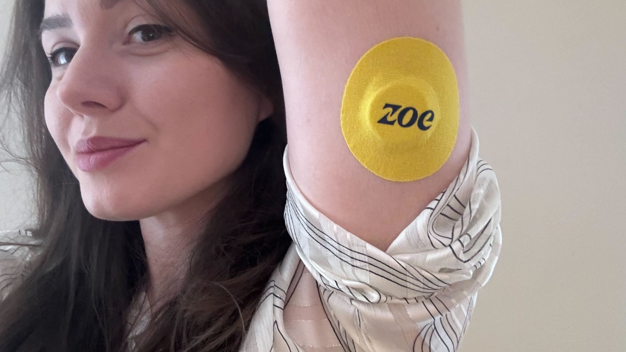  Josephine Watson, Managing Editor of Lifestyle at TechRadar, holding her arm up to show the attached Zoe CGM. 