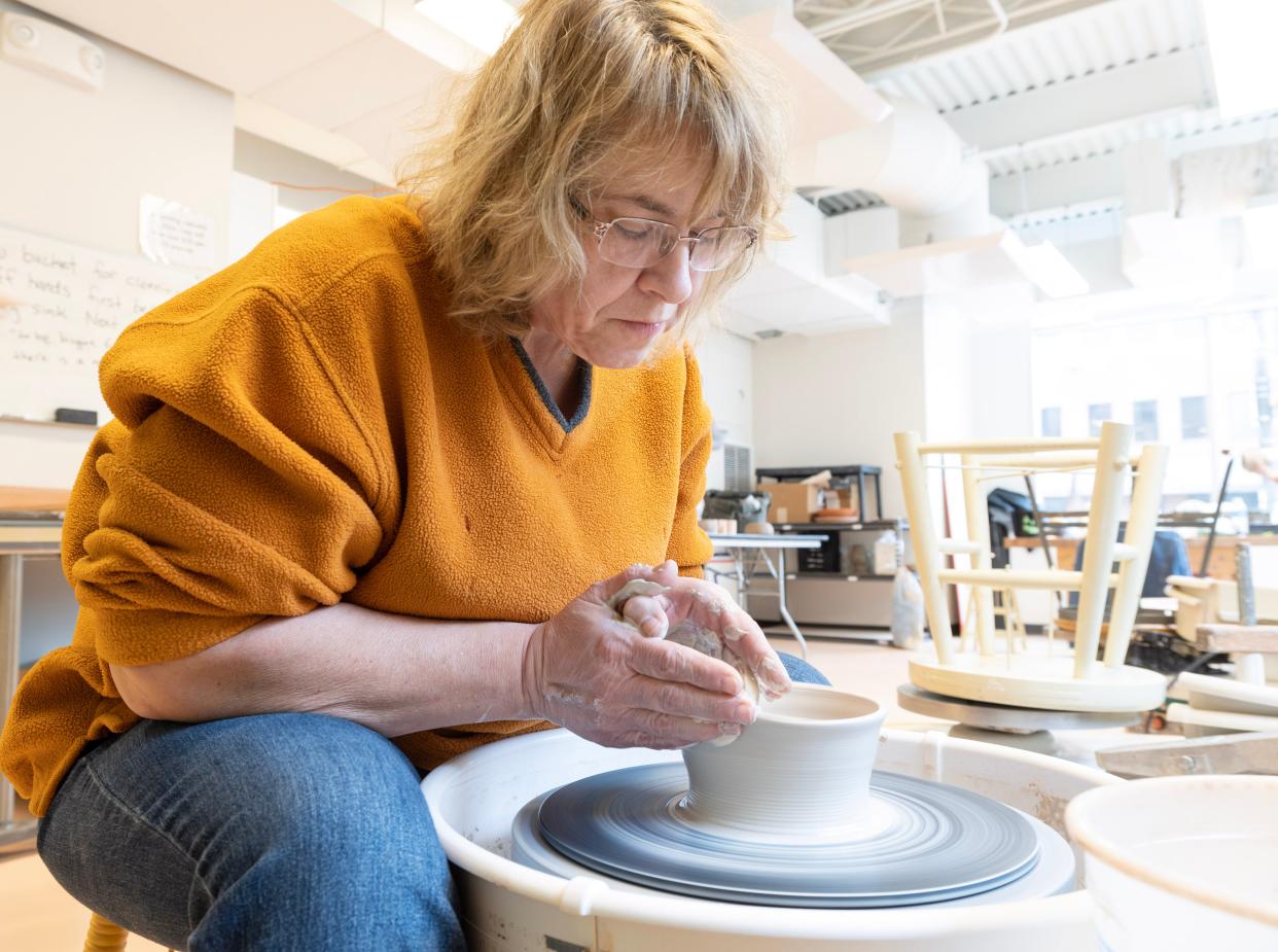 Becky Carpenter throws a ramen bowl on a pottery wheel at the Massillon Museum ceramics studio.