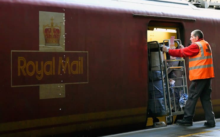 Royal Mail employee loads packages onto train