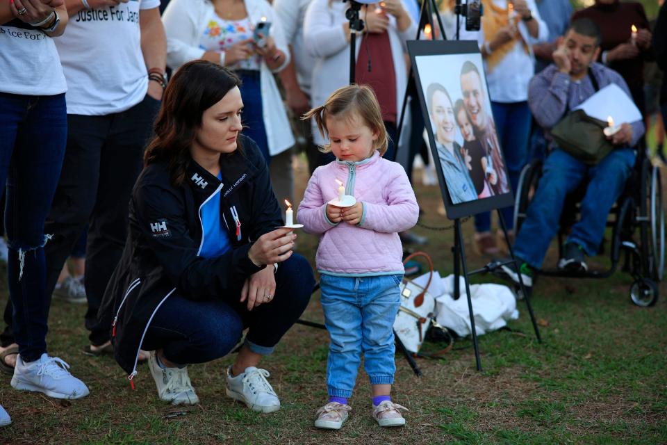 Kirsten Bridegan and daughter Bexley, 2, look at the flames on their candles during a vigil April 19, 2022, at South Beach Park and Sunshine Playground in Jacksonville Beach. Dozens came out to honor the memory of Jared Bridegan, killed on Feb. 16 near the exit of The Sanctuary neighborhood in Jacksonville Beach in front of his toddler.