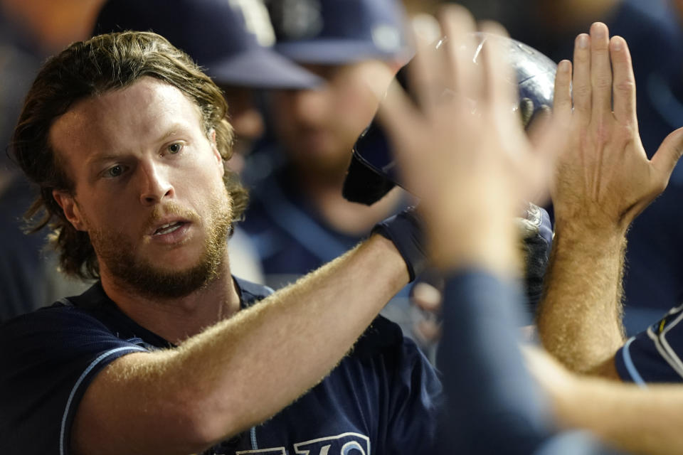 Tampa Bay Rays' Brett Phillips is congratulated after scoring in the seventh inning of the team's baseball game against the Cleveland Indians, Saturday, July 24, 2021, in Cleveland. (AP Photo/Tony Dejak)