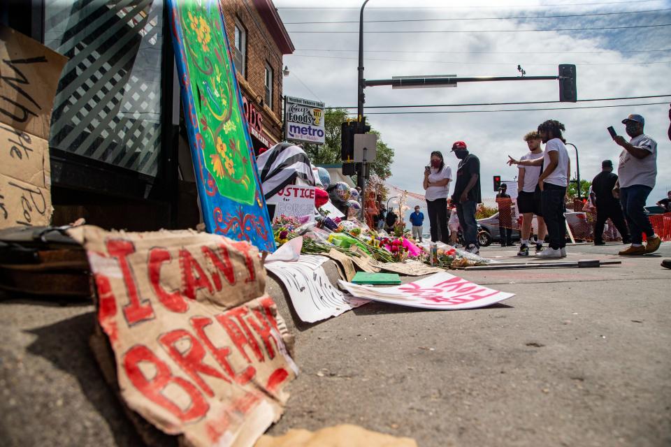 Mourners gather at a memorial for George Floyd on the corner of 38th and Chicago in Minneapolis Wednesday, May 27, 2020. 