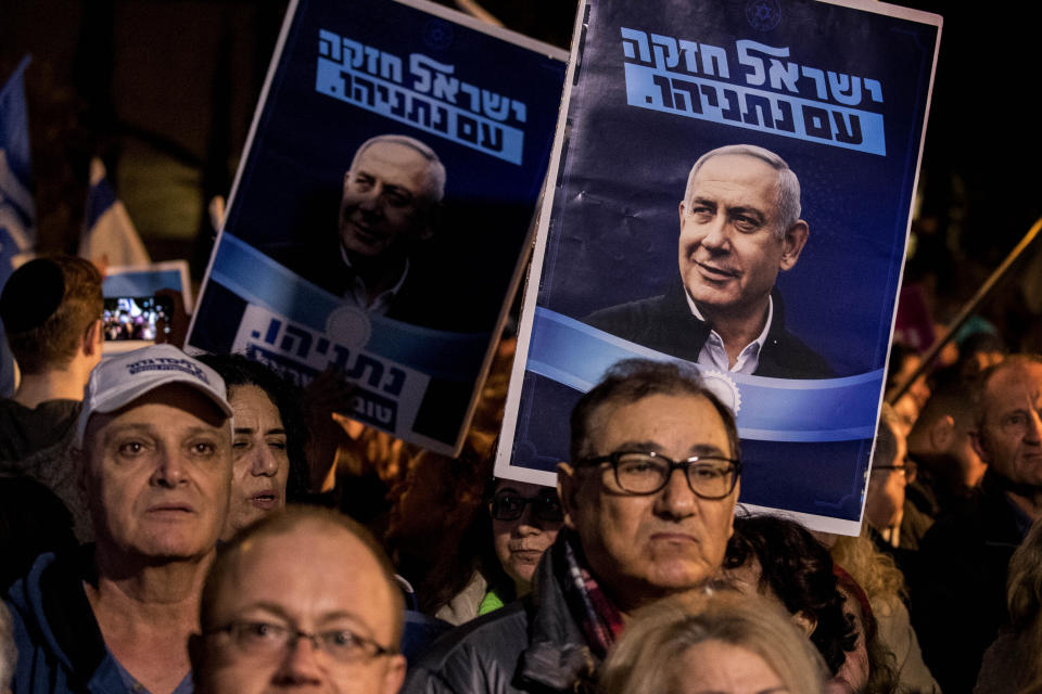 Supporters of the Israeli Prime Minister Benjamin Netanyahu rally outside Israel's parliament in Jerusalem, Wednesday, Dec. 11, 2019. The Israeli parliament began voting to dissolve itself on Wednesday and pave the path to an unprecedented third election within a year. Hebrew in posters reads: "Netanyahu Israel is strong." (AP Photo/Tsafrir Abayov)