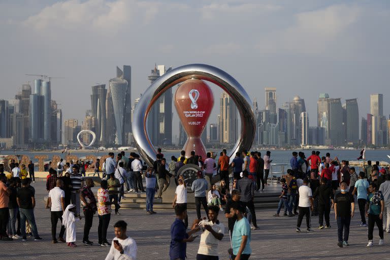 ARCHIVO - Un grupo de personas se reúne en torno de un reloj que marca la cuenta regresiva para la inauguración del Mundial en Doha, Qatar, el 11 de noviembre de 2022 (AP Foto/Hassan Ammar, archivo)