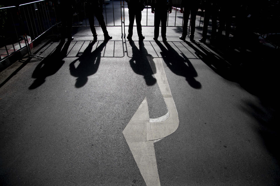 Shadows of standing police officers cast on the ground at the entrance to the criminal courthouse in Bangkok, Thailand, Thursday, Sept. 3, 2020. (AP Photo/Gemunu Amarasinghe)