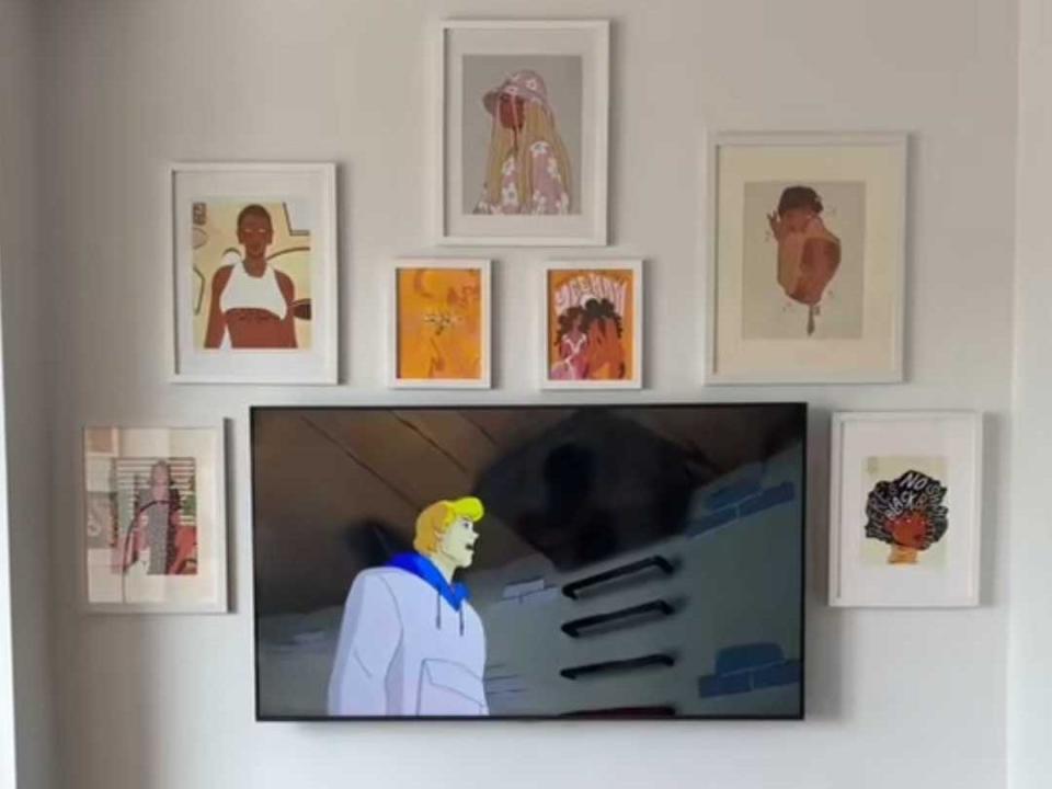 A living-room area with TV turned into "Scooby-Doo" and a gallery wall surrounding area