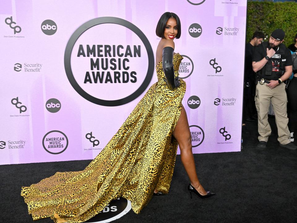 Kelly Rowland wearing animal print dress with black gloves