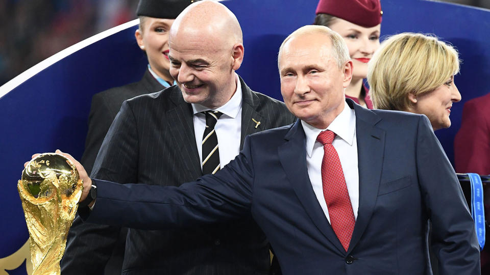 Seen here, Russian President Vladimir Putin poses for a photo with the FIFA World Cup trophy.
