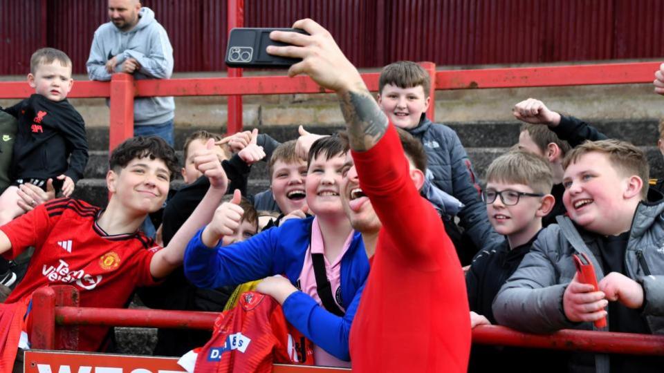 News and Star: Top scorer and captain Dav Symington take a selfie with young Reds fans