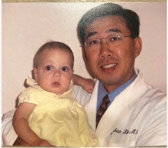 In this family photo, transplant surgeon Heung Bae Kim holds Reagan Devlin, who had a liver transplant when she was about a month old that saved her life. Kim led the team that performed the transplant.