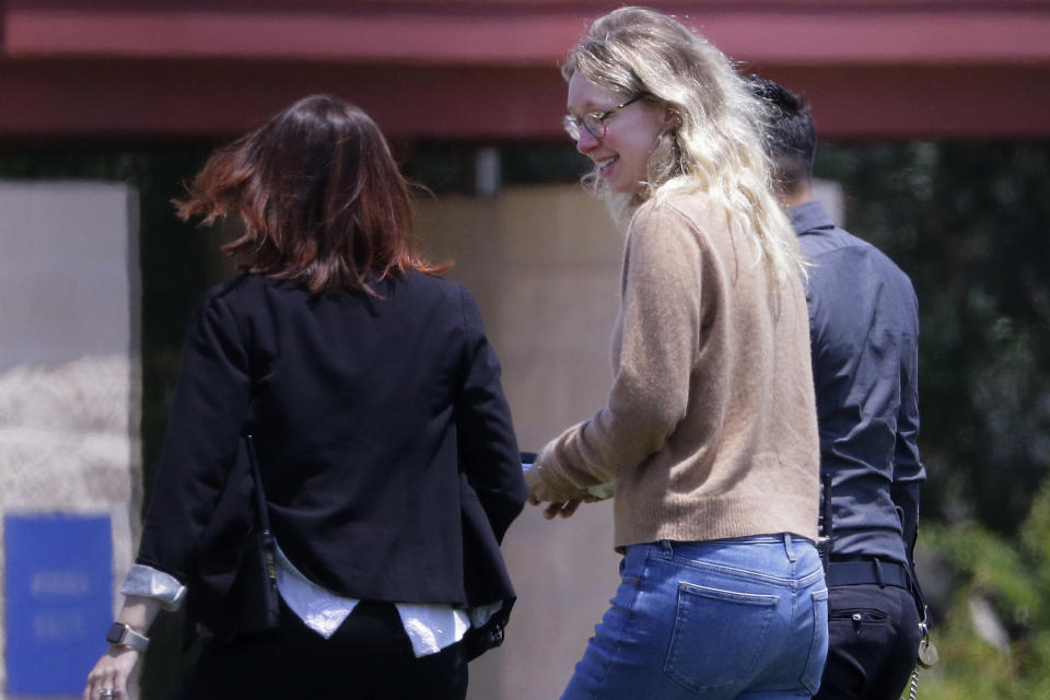 FILE - Former Theranos CEO Elizabeth Holmes, center, is escorted by prison officials into a federal women's prison camp on May 30, 2023, in Bryan, Texas. A panel of appeals court judges will preside over oral arguments on Tuesday, June 11, 2024, in an attempt to overturn the 2022 fraud conviction of Holmes in the high-profile case that exposed the greed and hubris infecting Silicon Valley. (AP Photo/Michael Wyke, File)