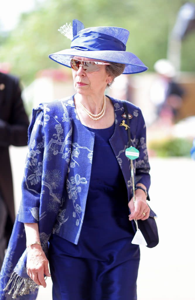 <p>Princess Anne arrived for the day's races wearing a royal blue ensemble, a pair of sporty <a href="https://www.townandcountrymag.com/society/tradition/g36395845/royal-family-favorite-sunglasses-brands/#:~:text=The%20Royal%20Family's%20Favorite%20Sunglasses&text=If%20there's%20one%20brand%20the,on%2C%20it's%20Ray%2DBan." rel="nofollow noopener" target="_blank" data-ylk="slk:sunglasses;elm:context_link;itc:0;sec:content-canvas" class="link ">sunglasses</a>, and a horse-themed brooch.</p>