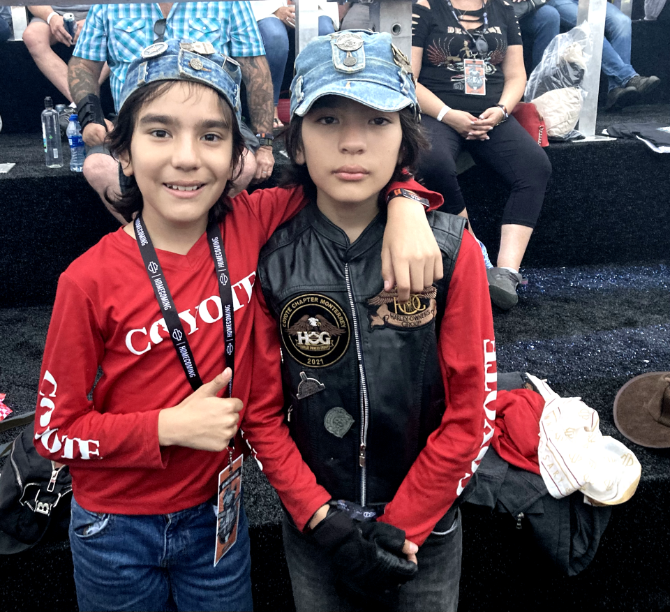 The Gonzalez twin brothers wearing coyote chapter outfits and enjoying themselves at the Harley-Davidson 120th anniversary in Veteran's Park.