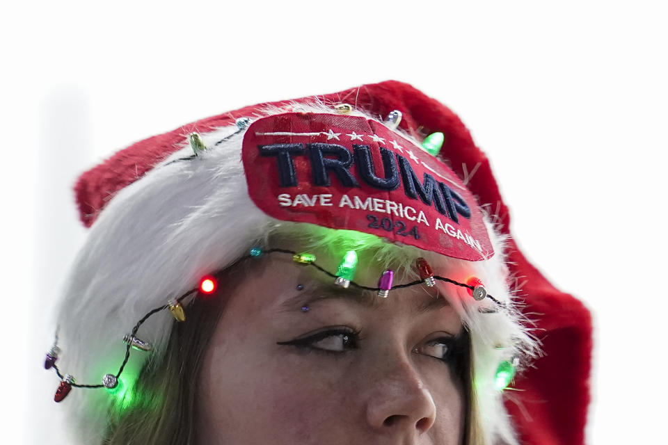 A woman wears a Santa Claus hat while attending a rally where former President Donald Trump delivered remarks Sunday, Dec. 17, 2023, in Reno, Nev. (AP Photo/Godofredo A. Vásquez)