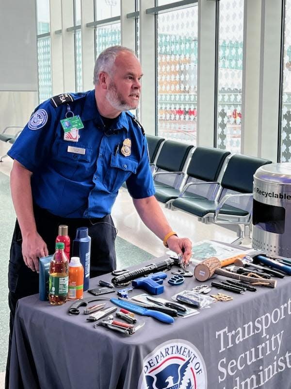 Transportation Security Officer Roger Ellison shows off items prohibited through airport checkpoints. Liquids, gels, aerosols, self-defense items and even guns are commonly surrendered at McGhee Tyson Airport