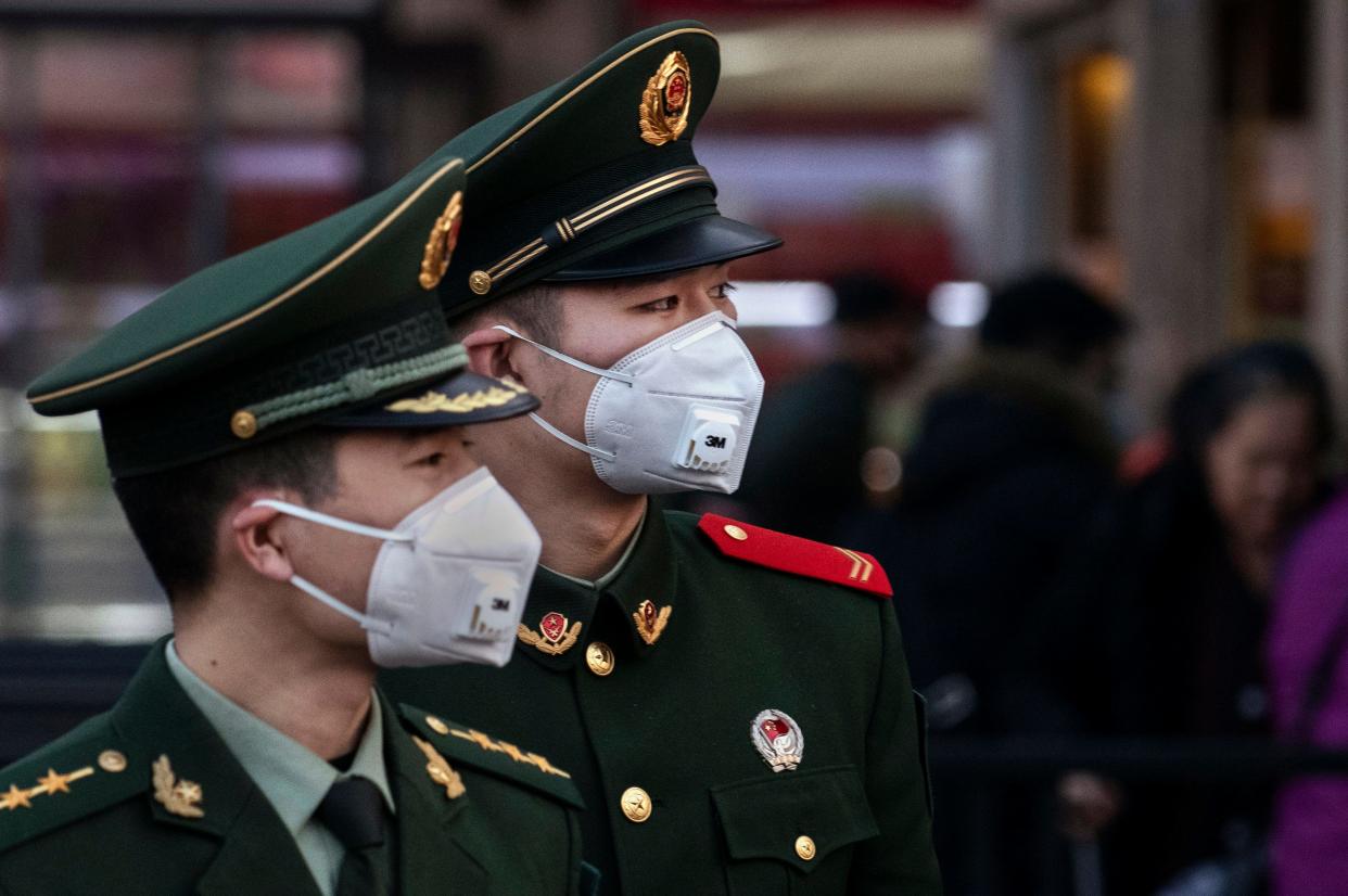 Chinese police officers wear protective masks at Beijing Station before the annual Spring Festival on January 22, 2020 in Beijing.