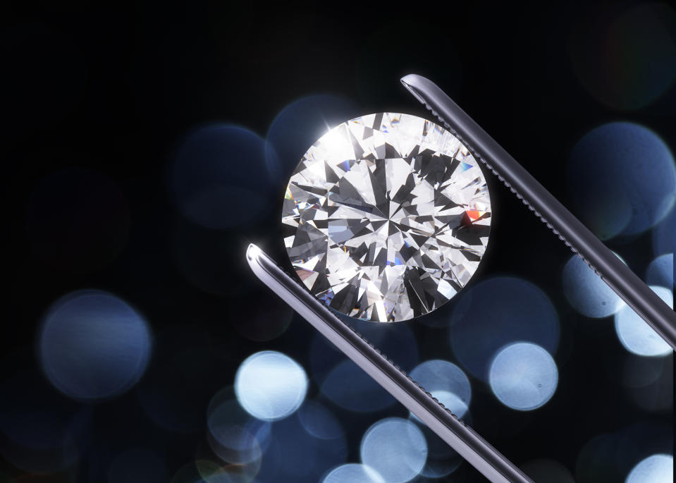 Jeweler's tweezers holding a diamond.