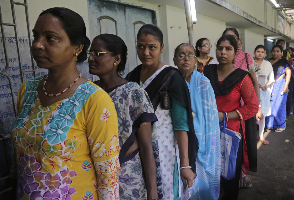 Indian voters stand in a queue to cast their votes at Podra in Howrah, India, Monday, May 6, 2019. With 900 million of India's 1.3 billion people registered to vote, the Indian national election is the world's largest democratic exercise. (AP Photo/Bikas Das)