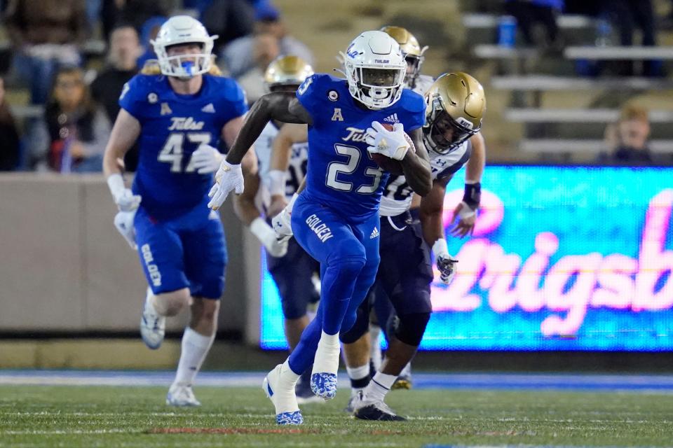 Tulsa running back Anthony Watkins (23) takes off on a 78-yard run in the first half of an NCAA college football game against Navy, Friday, Oct. 29, 2021, in Tulsa, Okla. (AP Photo/Sue Ogrocki)