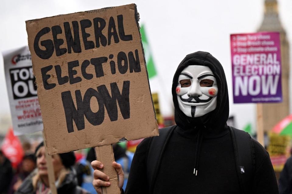 5 November 2022: Demonstrators with placards calling for a General Election march near the Houses of Parliament (AFP via Getty Images)