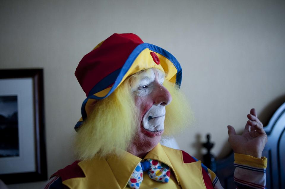 In this July 31, 2012 photo, Bob Neil, aka "Kiwi" the clown, gestures after making the finishing touches on his costume at the third annual Clown Campin' in Ontario, Calif. The week long event is held for clowns across the United States and Canada to learn, get inspired, and network.(AP Photo/Grant Hindsley)