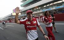 Ferrari Formula One driver Fernando Alonso of Spain waves to his fans at the Buddh International Circuit in Greater Noida on the outskirts of New Delhi October 24, 2013. The Indian F1 Grand Prix will take place from October 25-27. REUTERS/Adnan Abidi (INDIA - Tags: SPORT MOTORSPORT F1)