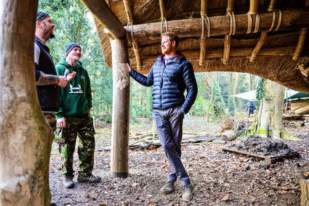 Prince Harry speaks with Mike Day (left) and Eddie Beddoes (second left) underneath a mud, wood and thatched round house in the woodland area during a visit to a Help For Heroes Recovery Centre at Tedworth House, where he learnt more about the mental health support military veterans are receiving, in Tidworth, Wiltshire, Britain January 23, 2017. REUTERS/Ben Birchall/Pool