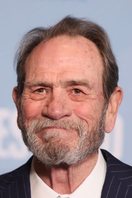 Tommy Lee Jones smiling in a suit at an event