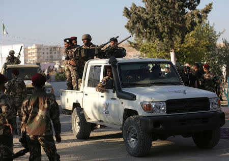 Fighters of National Army, backed by Turkey, stand at a back of a truck in the city of al-Bab, Syria August 5, 2018. REUTERS/Khalil Ashawi