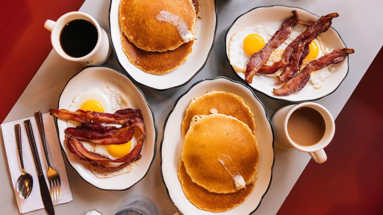 american breakfast at the diner with fried eggs, bacon and pancakes