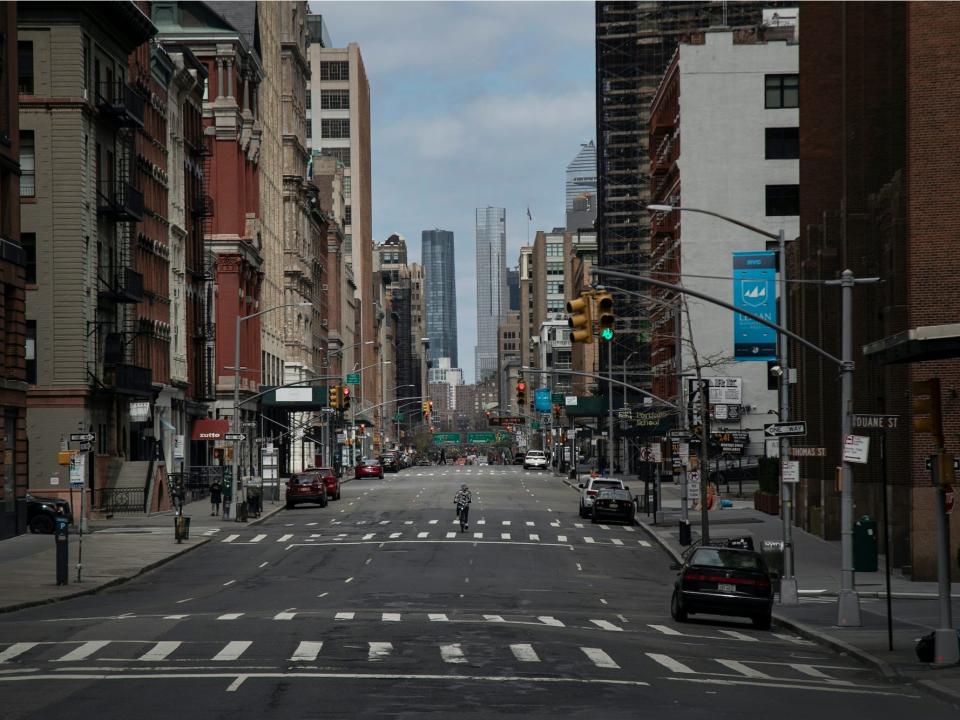 In this March 22, 2020, file photo, a cyclist rides his bicycle down the middle of a main road in downtown New York
