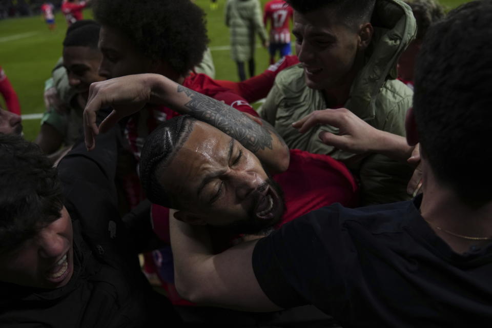 Atletico Madrid's Memphis Depay celebrates with fans and teammates after scoring his side's second goal during the Champions League, round of 16, second leg soccer match between Atletico Madrid and Inter Milan at the Metropolitano stadium in Madrid, Spain, Wednesday, March 13, 2024. (AP Photo/Manu Fernandez)